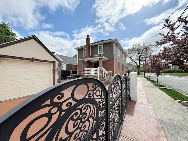 view of front of home featuring fence, brick siding, and a garage