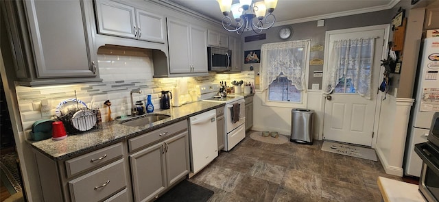 kitchen featuring white appliances, a sink, ornamental molding, decorative backsplash, and an inviting chandelier