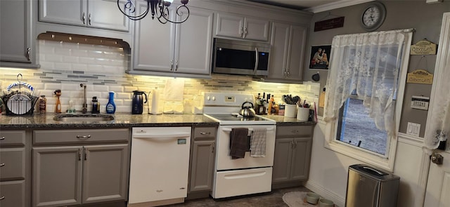 kitchen featuring white appliances, backsplash, a sink, and gray cabinetry