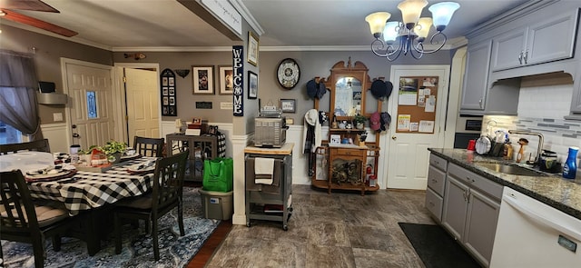 dining space featuring wainscoting, crown molding, and an inviting chandelier