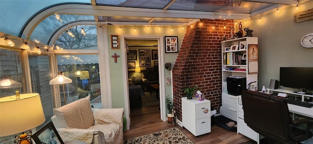 home office with brick wall and wood finished floors