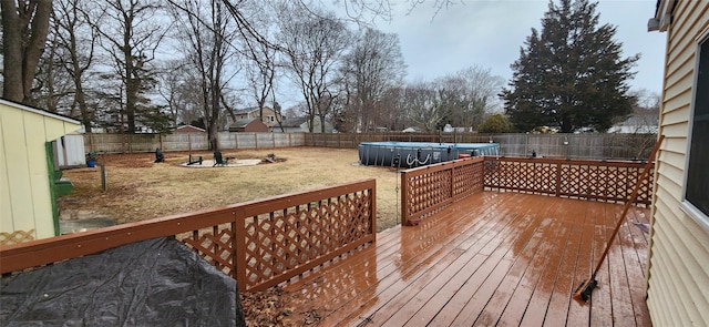 wooden deck featuring a fenced backyard, a lawn, and a fenced in pool