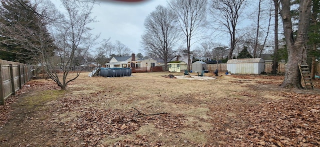 view of yard featuring a fenced in pool, an outbuilding, a fenced backyard, and a storage shed