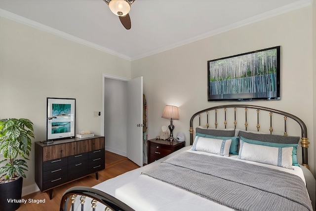 bedroom featuring baseboards, wood finished floors, a ceiling fan, and ornamental molding