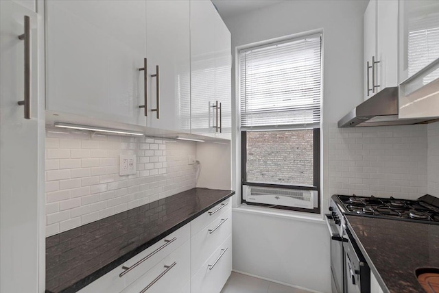 kitchen with backsplash, stainless steel range with gas cooktop, and white cabinetry