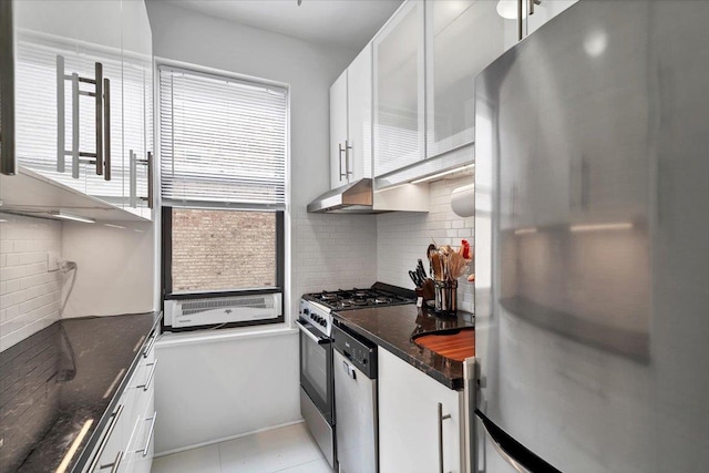 kitchen featuring under cabinet range hood, decorative backsplash, white cabinets, and appliances with stainless steel finishes