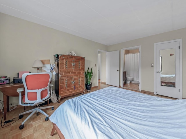 bedroom with ensuite bath and baseboards