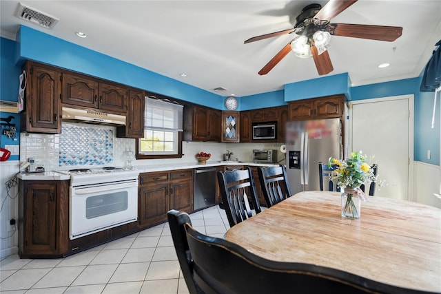 kitchen featuring stainless steel appliances, light countertops, visible vents, and under cabinet range hood