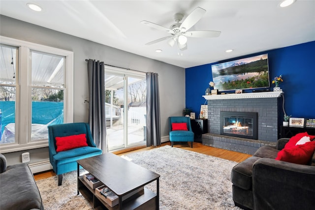 living area featuring a fireplace, wood finished floors, and recessed lighting