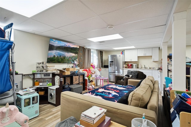 living area with a drop ceiling and light wood finished floors