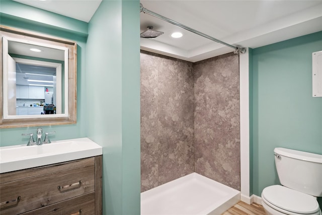 bathroom with a stall shower, baseboards, vanity, and toilet