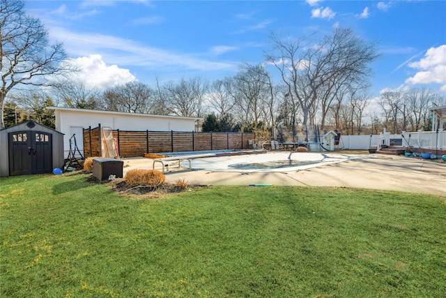 view of yard with an outbuilding, a storage unit, a patio area, and fence