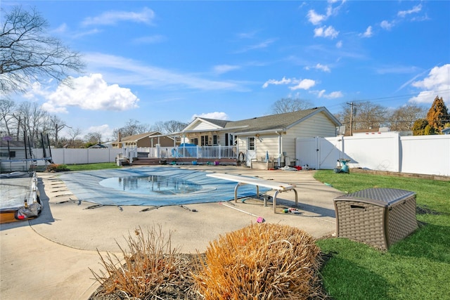 view of swimming pool featuring a patio, a fenced backyard, a gate, a fenced in pool, and a trampoline