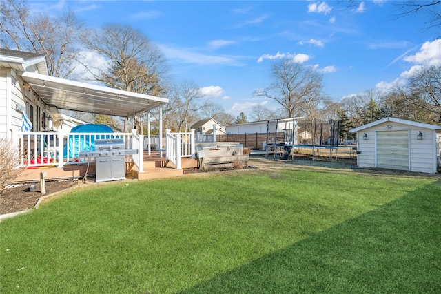 view of yard with a trampoline, a storage shed, fence, an outdoor structure, and a wooden deck