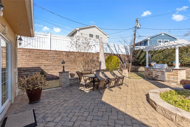 view of patio with fence private yard, a grill, exterior kitchen, a pergola, and outdoor dining space