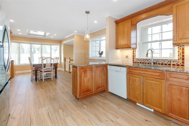 kitchen featuring a sink, ornamental molding, decorative backsplash, and dishwasher