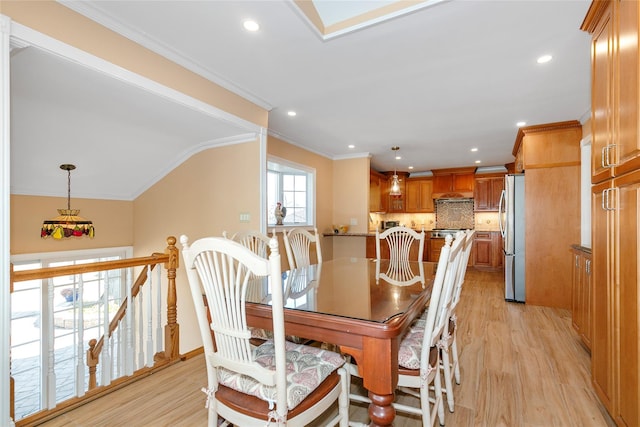 dining room with crown molding, recessed lighting, light wood-style floors, vaulted ceiling, and baseboards