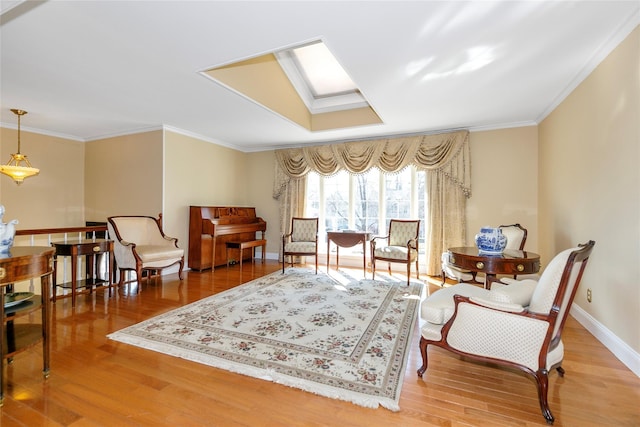 sitting room featuring a skylight, baseboards, wood finished floors, and ornamental molding