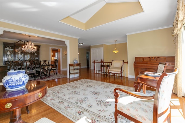 living room with an inviting chandelier, baseboards, ornamental molding, and wood finished floors