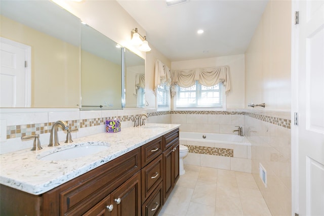 bathroom with a bath, tile patterned flooring, double vanity, and a sink