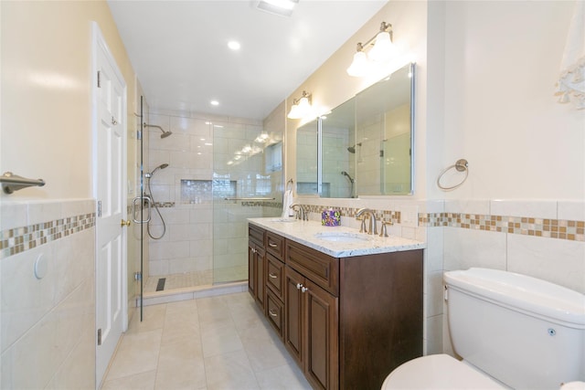 bathroom with toilet, a stall shower, a sink, and tile walls