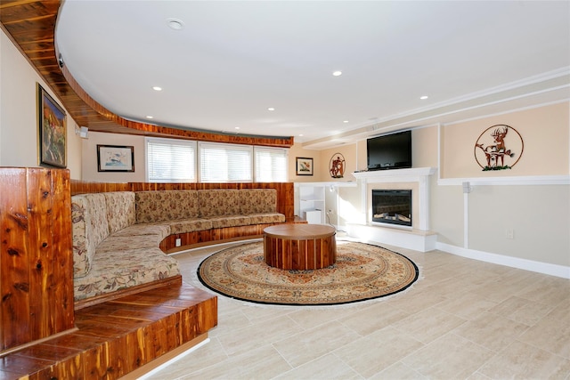 living room with recessed lighting, baseboards, and a glass covered fireplace