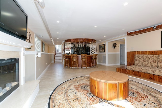 tiled living room with recessed lighting, bar area, and a premium fireplace