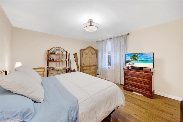 bedroom with wood finished floors and baseboards