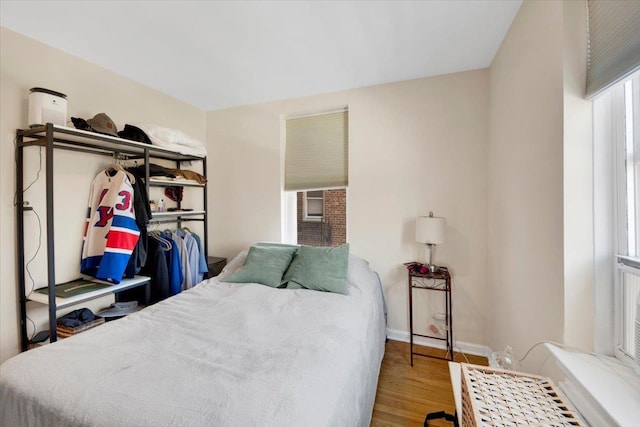 bedroom with baseboards and wood finished floors