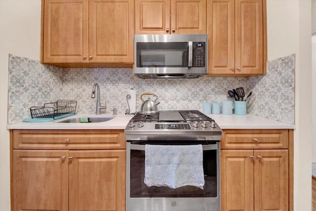 kitchen with stainless steel appliances, backsplash, a sink, and light countertops