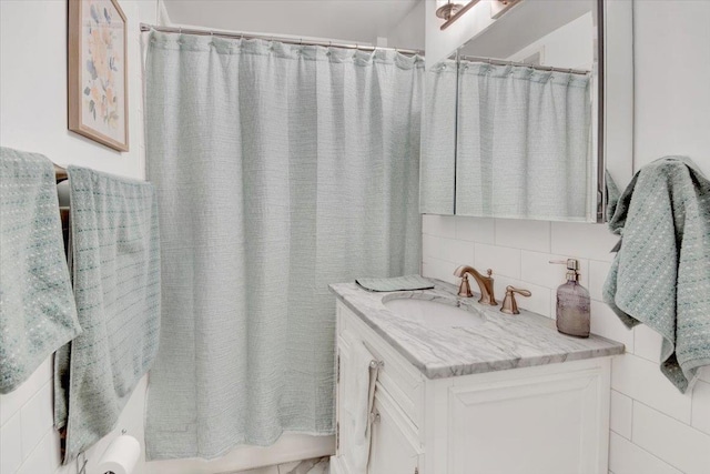 full bath with tasteful backsplash, shower / tub combo with curtain, and vanity