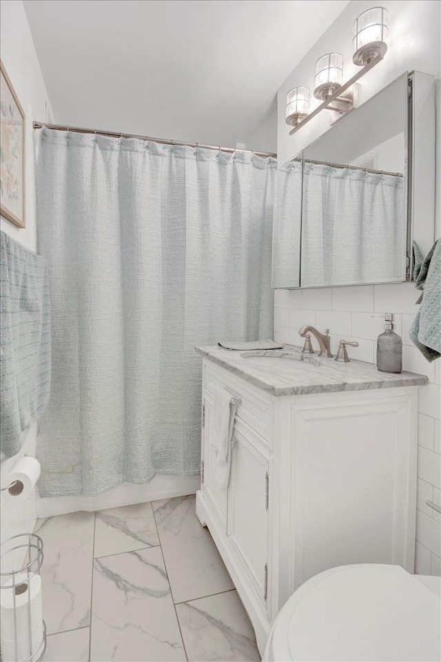 full bath with marble finish floor, vanity, and toilet