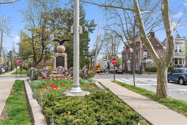 exterior space featuring sidewalks, traffic signs, a residential view, and curbs