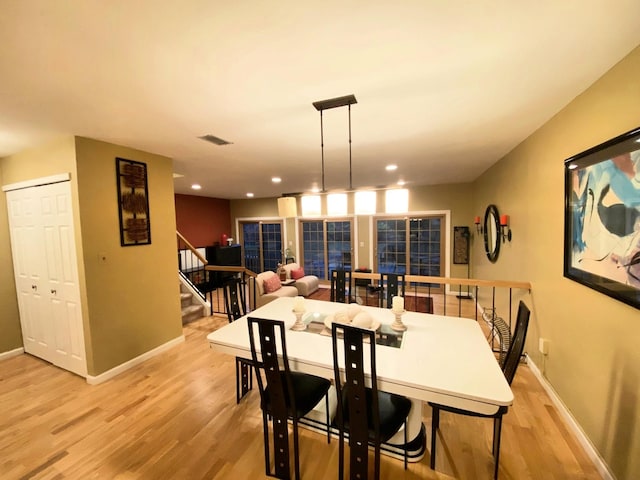 dining room with baseboards, stairway, visible vents, and light wood-style floors