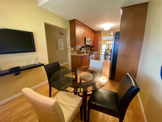 dining room with light wood-type flooring and baseboards