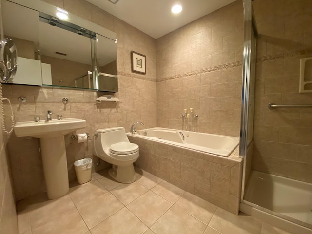 full bathroom featuring a stall shower, toilet, a garden tub, tile patterned flooring, and tile walls