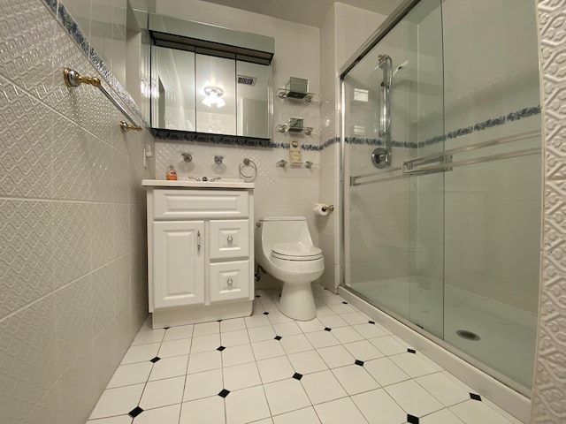 bathroom with toilet, a shower stall, tile walls, and vanity