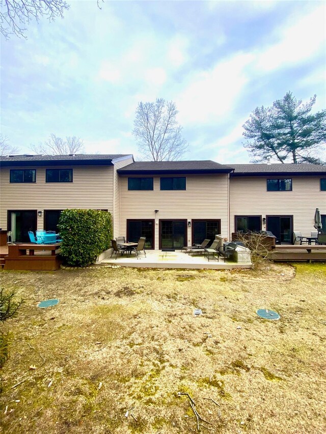 back of house featuring a deck and a patio