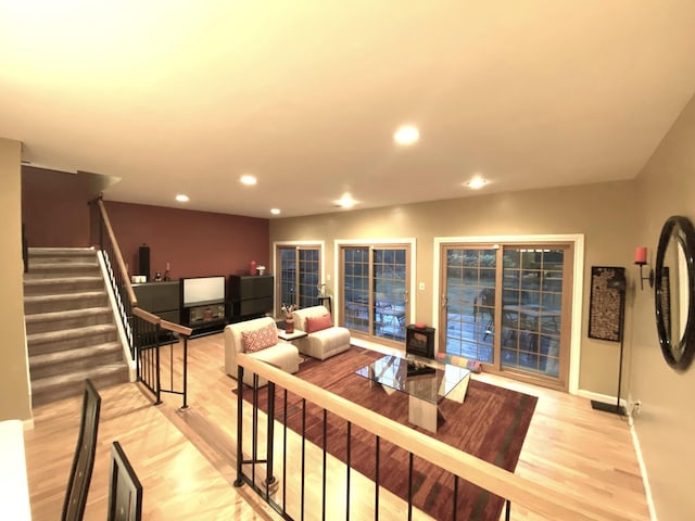 living area featuring baseboards, light wood finished floors, stairway, and recessed lighting