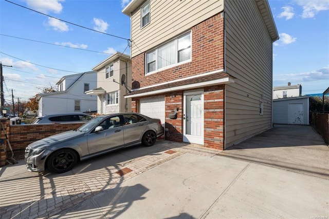 view of property exterior featuring brick siding, driveway, and an attached garage