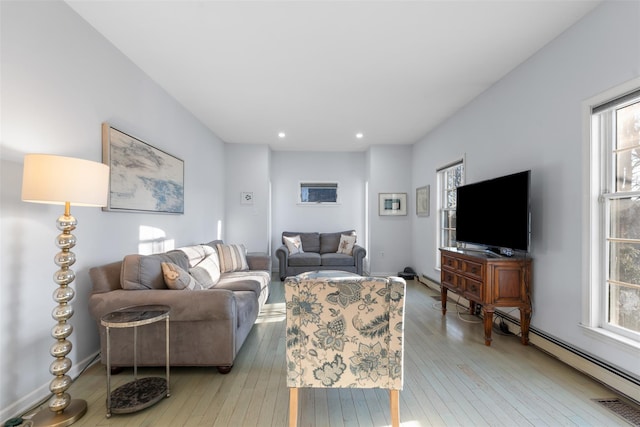 living room with a baseboard heating unit, wood-type flooring, baseboards, and recessed lighting