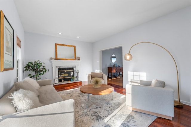 living room with recessed lighting, wood finished floors, and a glass covered fireplace