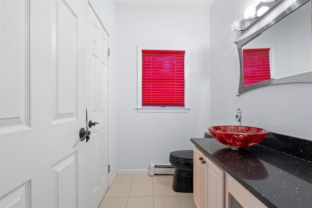 bathroom with a baseboard radiator, toilet, vanity, baseboards, and tile patterned floors