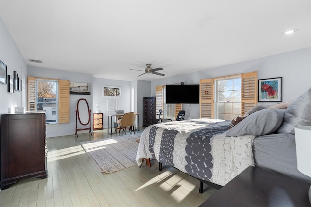 bedroom with visible vents, ceiling fan, hardwood / wood-style floors, and multiple windows