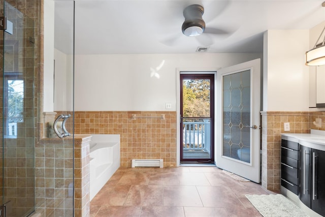 bathroom featuring ceiling fan, a baseboard heating unit, visible vents, tile walls, and a shower stall