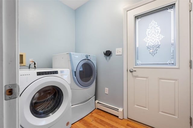 laundry area featuring a baseboard heating unit, washing machine and dryer, laundry area, and light wood-type flooring