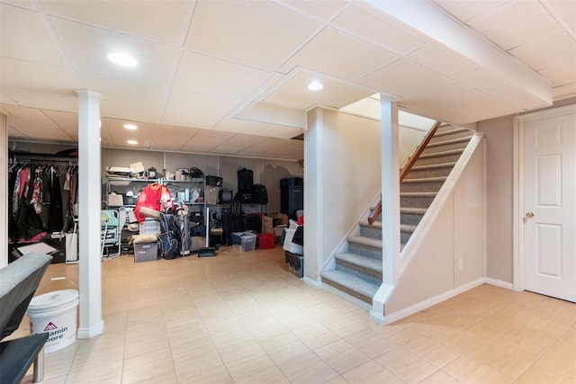 finished basement with recessed lighting, a drop ceiling, and stairs