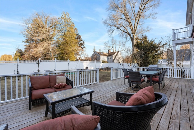 wooden deck with outdoor dining area, a fenced backyard, and an outdoor living space