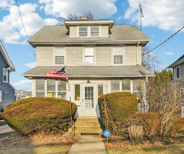 american foursquare style home with roof with shingles and a chimney