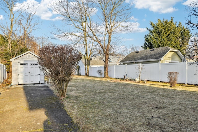 view of yard with an outbuilding, a shed, and a fenced backyard